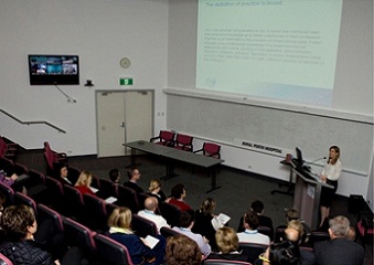 Picture of a lecture theatre full of people watching a presentation. 