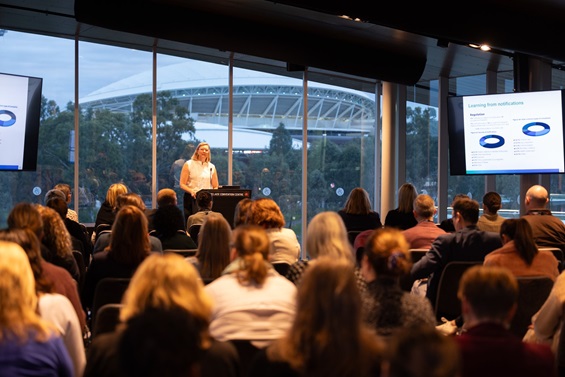 A woman speaking to a large audience